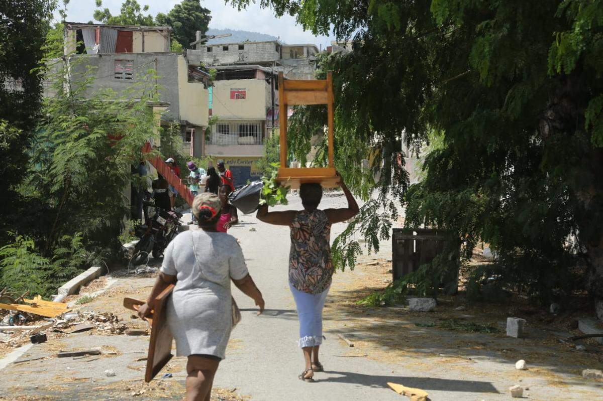 Residents in Delmas 30 in Haiti’s capital, carrying furniture after Jimmy “Barbecue” Chérizier, a leader of the Viv Ansanm gang coalition, announced in a video on social media that displaced residents can return home.