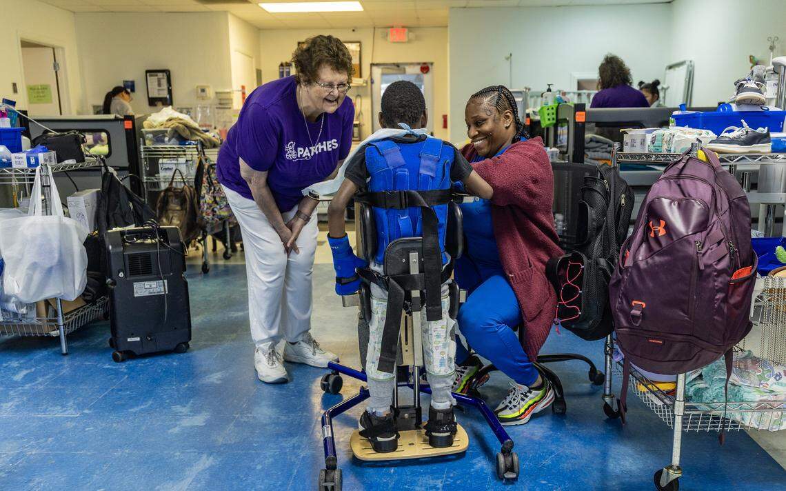 Kyle Smith (left), CEO-Co Founder of Patches, shares with Shaniqua Garrod, a Certified Nurse Assistant as she feeds one of the patients attending the non-profit organization that offers families of seriously ill children daily care 12 hours a day, 5 days a week, from birth to 21 years old, regardless of ability to pay or insurance coverage, in Florida City, on October, 08 2025.