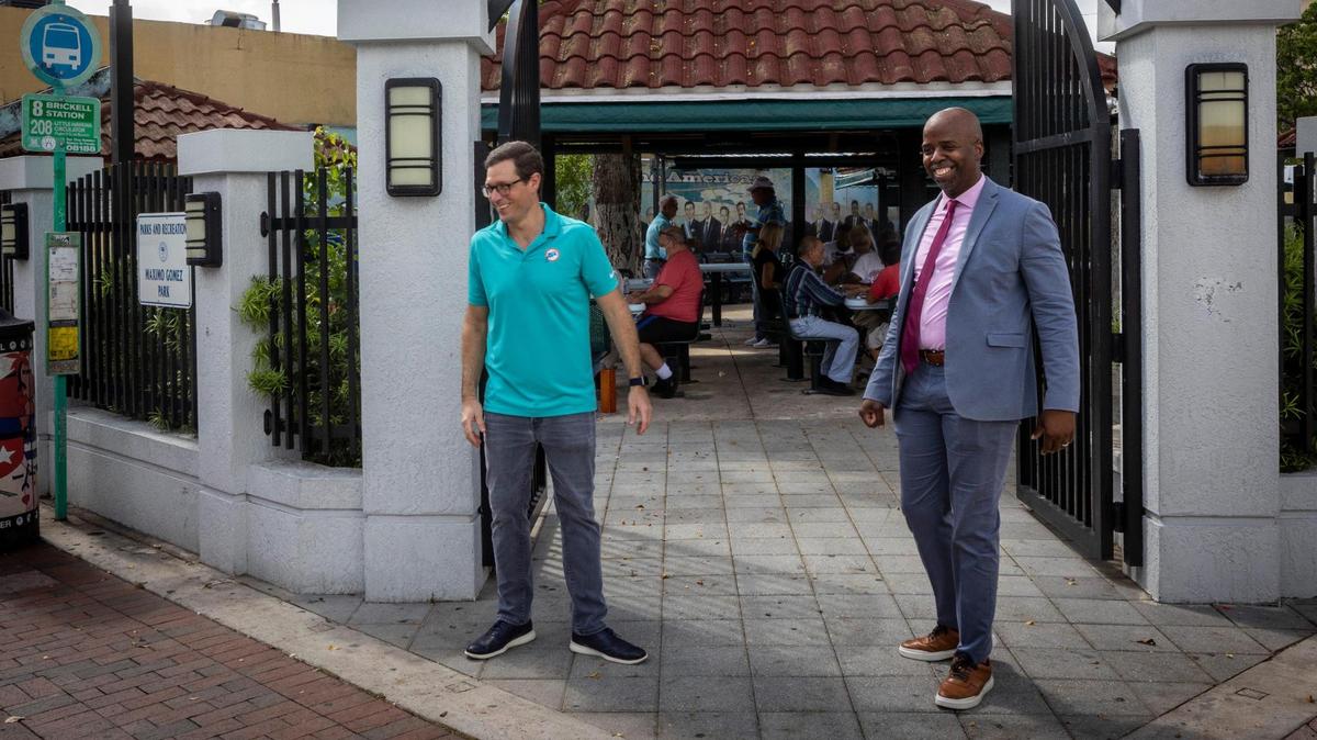 Marcus Bach-Armas, Director of Legal Affairs for the Miami Dolphins, left, and Jason Jenkins, Sr. VP Communications and Community Affairs pause in front of Maxim Gomez Park, also known as Domino Park during a tour of Little Havana.
