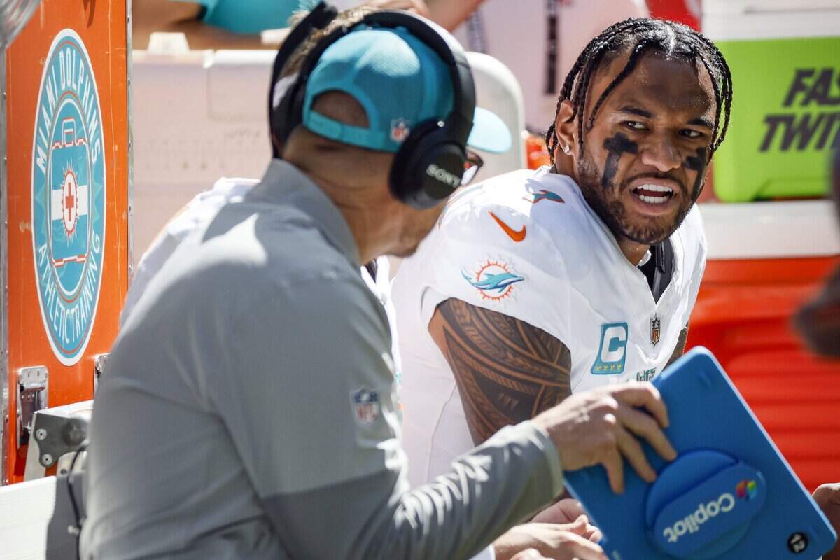 Miami Dolphins quarterback Tua Tagovailoa (1) speaks with Quarterbacks and Pass Game Coordinator Darrell Bevell in the second half of an NFL game against the Indianapolis Colts at Lucas Oil Stadium in Indianapolis on Sunday, September 7, 2025.