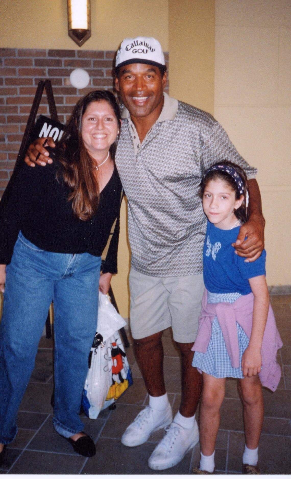 Teresita Gyori-Bosque and daughter Carolyn Bosque, 9, pose with O.J. SImpson in September 1999 after he and his kids ate and played at GameWorks in South Miami.