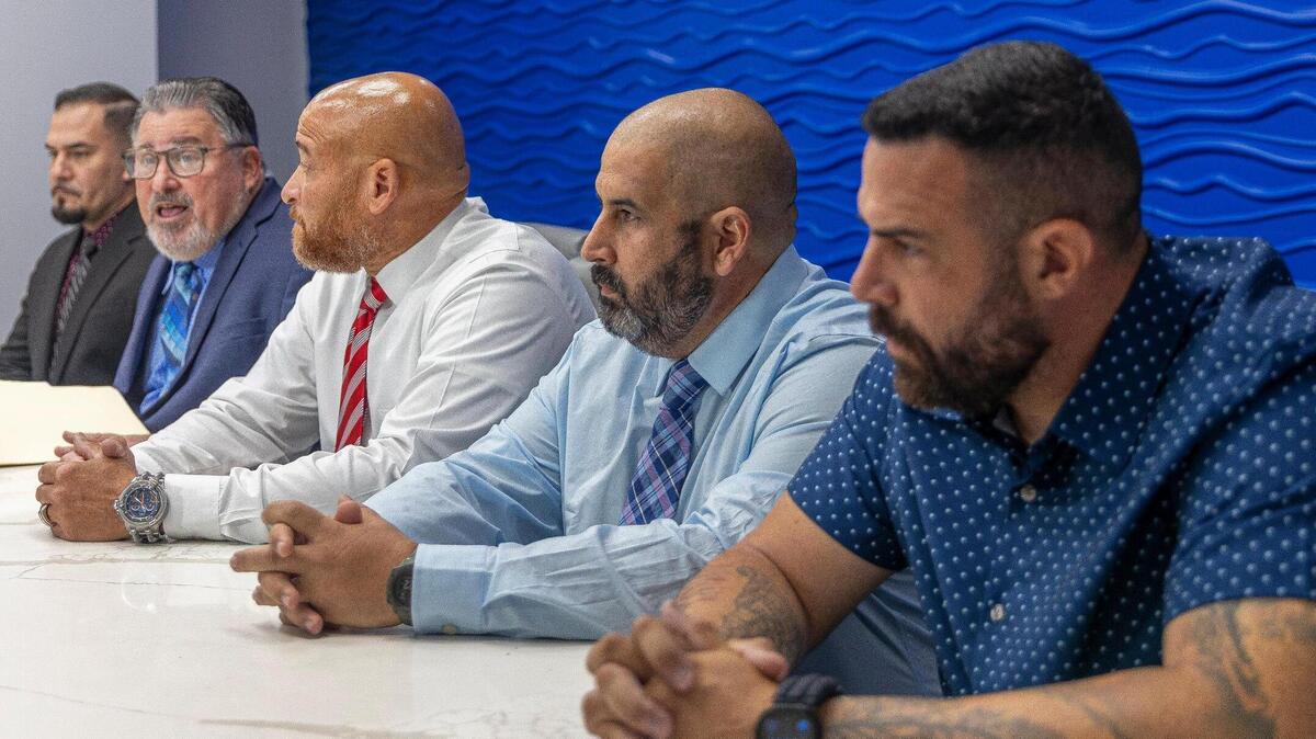 (Left) Officer Rudy Hernandez, Attorney Michael A Pizzi Jr., Officer Pedro Valdes, Officer Francisco Mejido, and Officer Juan Gonzalez, sit in front of the media to discuss a lawsuit they are filing against the Chief of Police Delma K. Noel-Pratt, on Wednesday, July 16, 2025, in Miami Lakes, Florida.