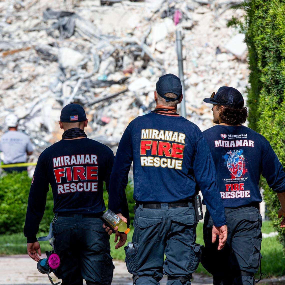 First responders from Miramar walk toward the rubble of the Champlain Towers South collapse, one day after a shift from search and rescue to recovery, in Surfside, Florida, on Thursday, July 8, 2021.