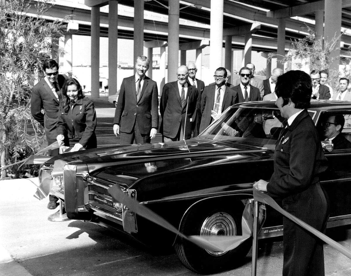 In 1970, parking officers hold a red ribbon as parking chairman Col. Mitchell Wolfson and Mayor Steve Clark break it with a blades to open a new parking lot under I-95 at West Flagler Street.