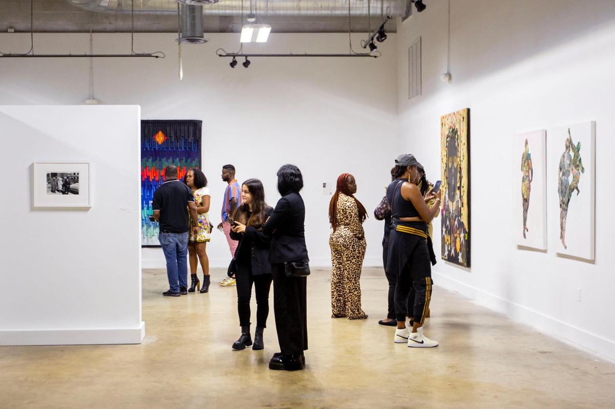 People socialize and view artwork during the Preview for The Art of Transformation event at The ARC and Logan Building in Opa-locka, Florida, on Wednesday, November 30, 2022. The event is a five-day, three-block Mecca of African and Haitian art fair coinciding with Art Basel Miami Beach 2022 and just one of over 40 ‘exhibits’ part of 2022 Art of Black Miami.