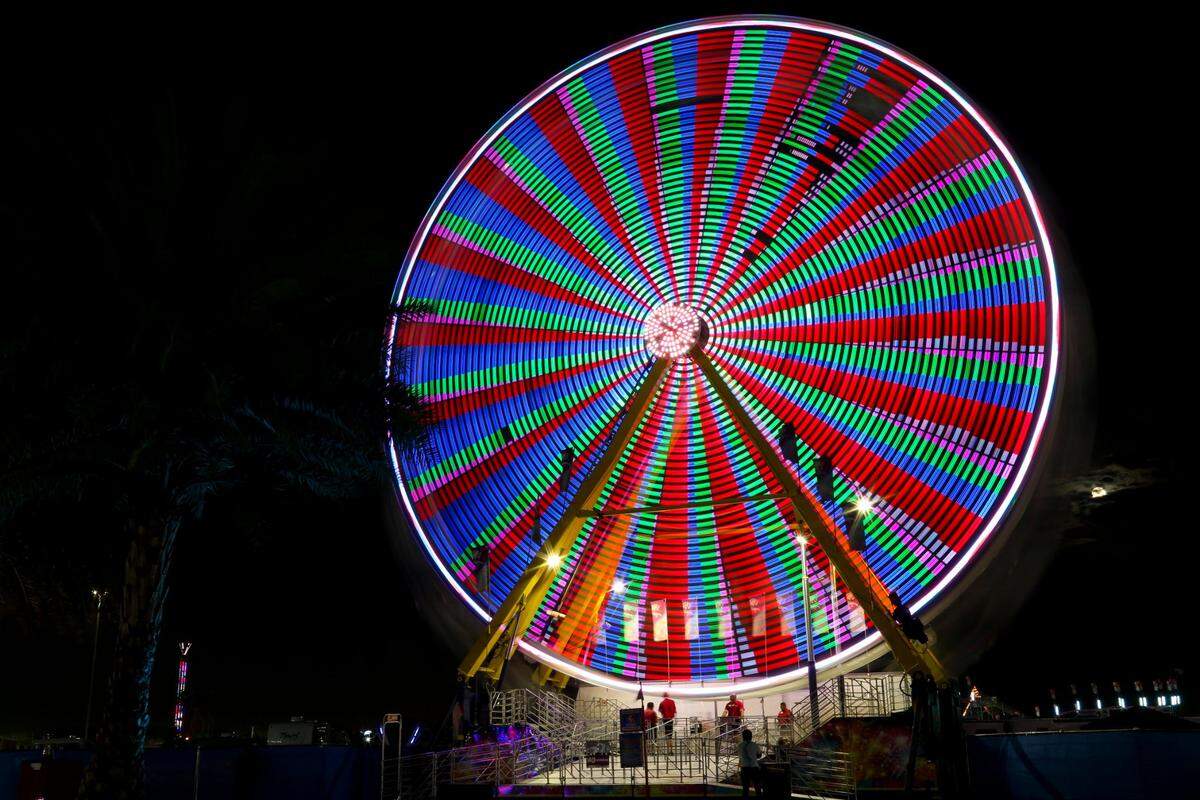 A Ferris wheels spins during the opening day of the Miami-Dade County Youth Fair at the Miami-Dade Fair & Expo Center in Miami, Florida, on Thursday, March 17, 2022.
