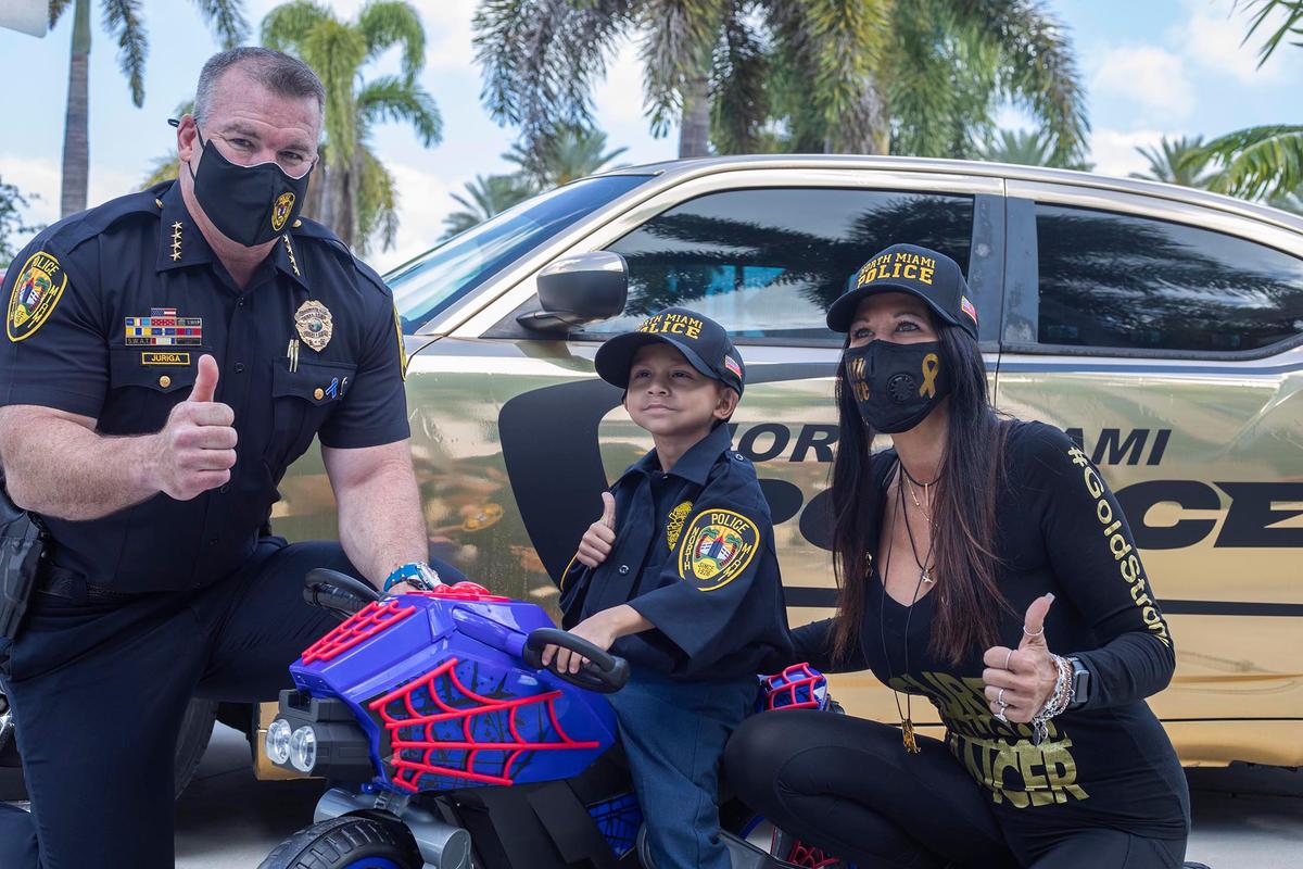 Jeremiah Valera, 5, poses with North Miami Police Chief Larry Juriga, left, and Sylvia Vanni at the North Miami police station March 20, 2021.