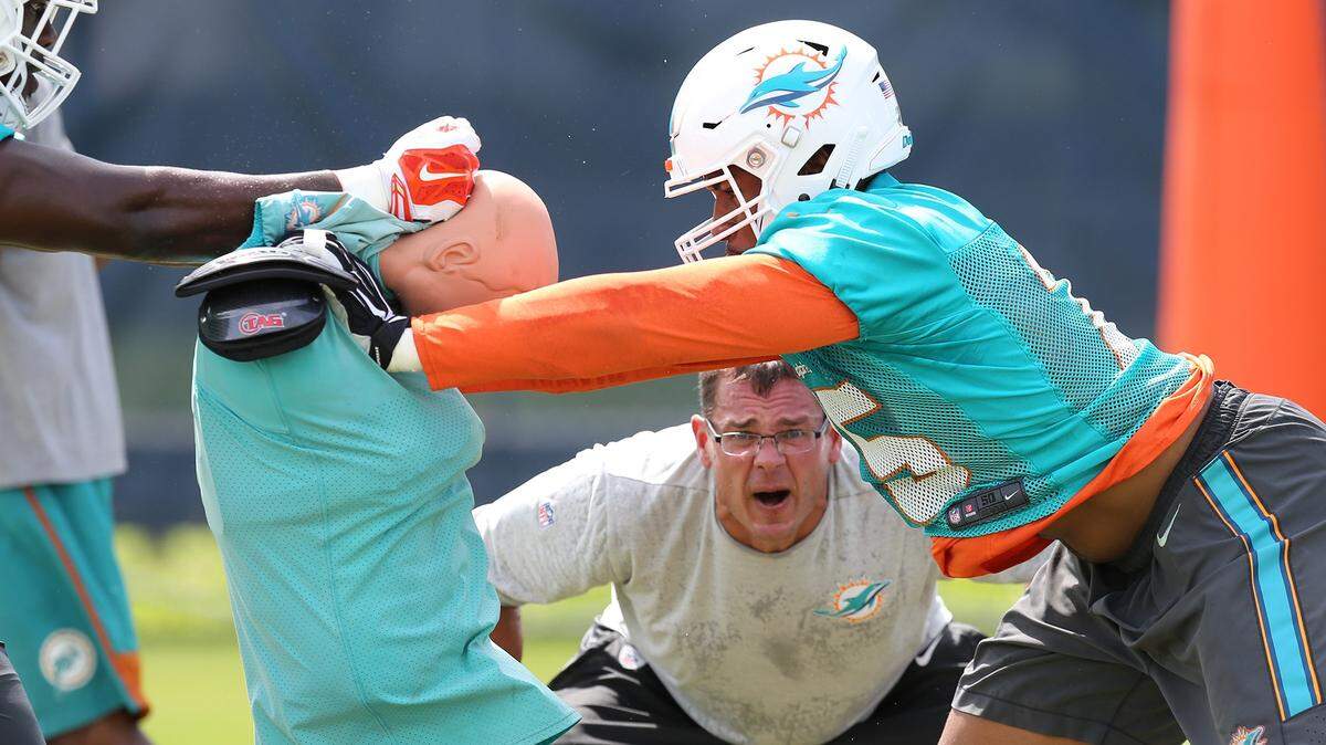 Defensive line coach Kris Kocurek, shown encouraging defensive end Cameron Malveaux during spring practice, is one of many new Dolphins faces.