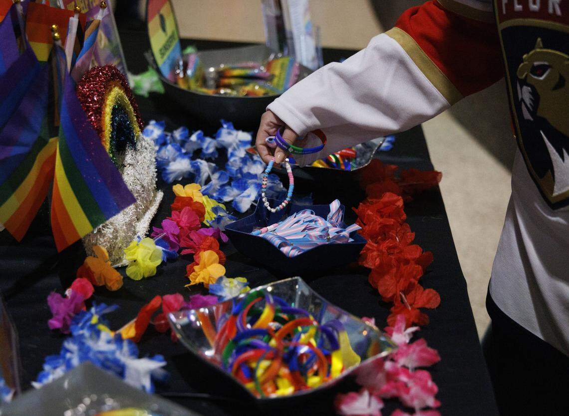 A Florida Panthers fan picks up Pride bracelets from a SunServe table during Florida Panthers Pride Night on Tuesday, March 31, 2026, at Amerant Bank Arena in Sunrise, Fla.