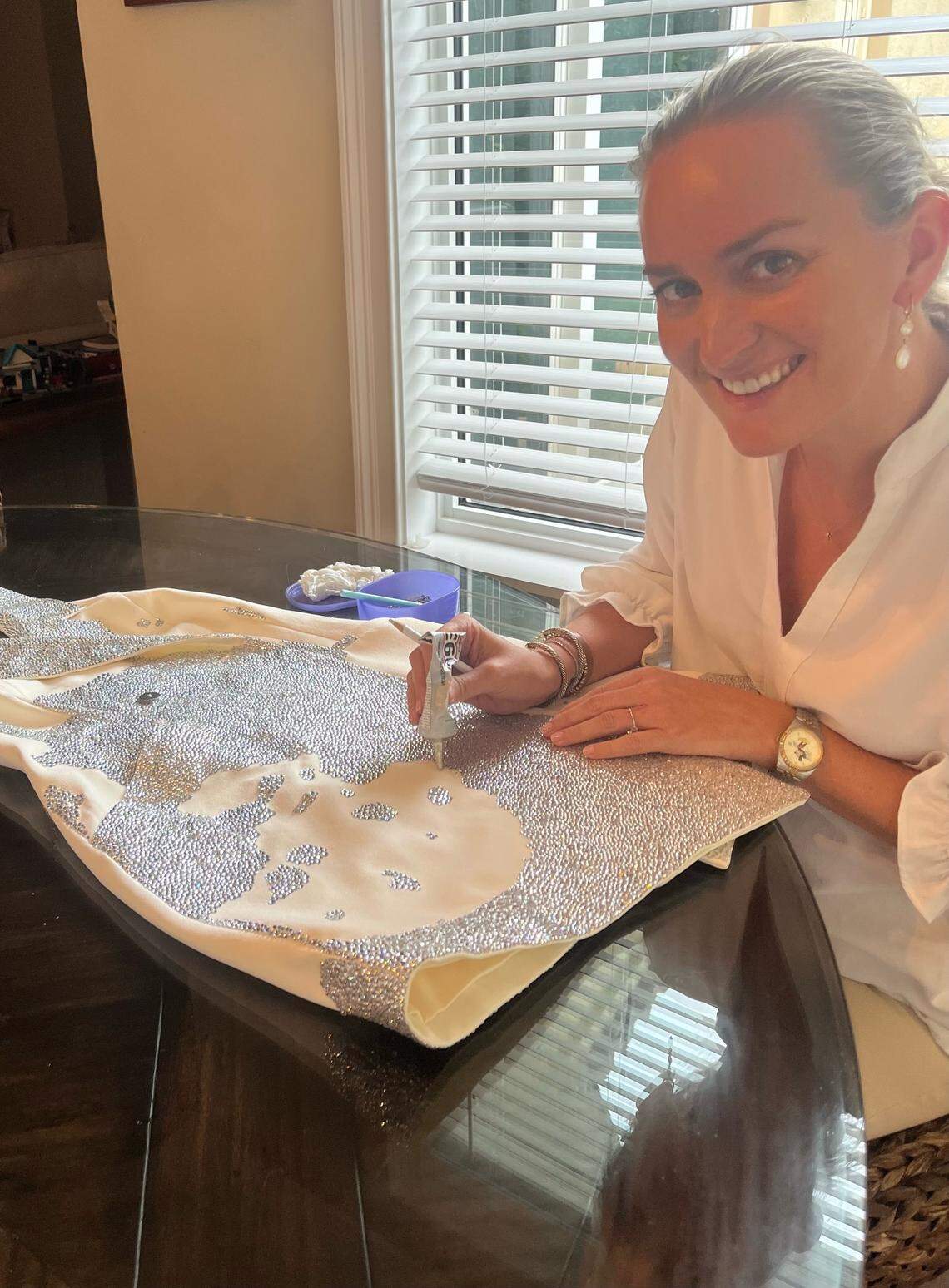 Amanda Lewis, a Taylor Swift fan, has been painstakingly applying rhinestones to the dress she plans to wear to the Miami concert.