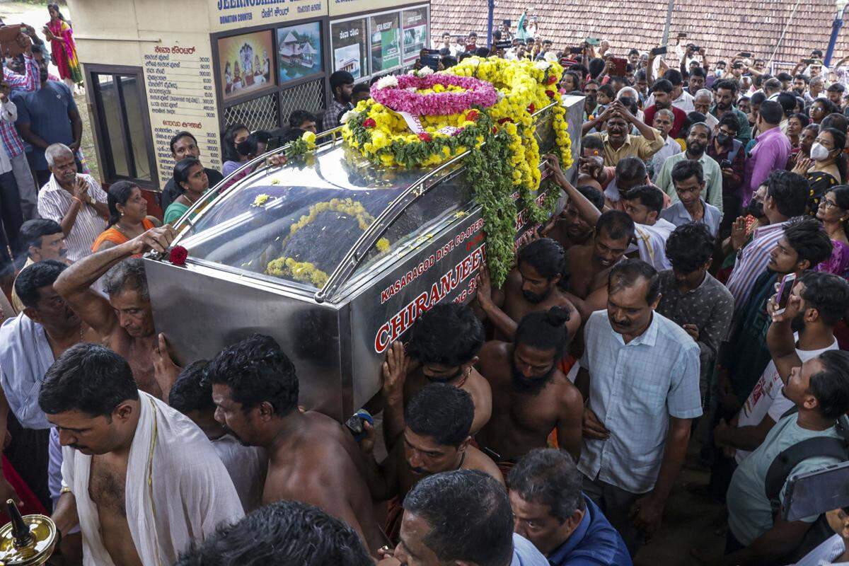 Funeral attendees carry the crocodile’s coffin.