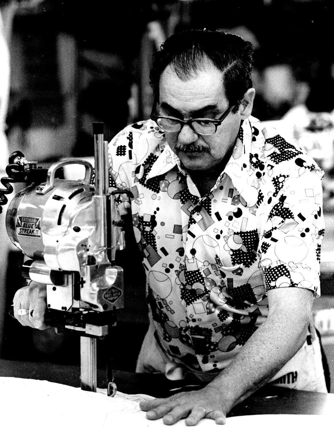 Camilo Criado, a worker at the Dorissa factory, cuts cloth for 900 garments.