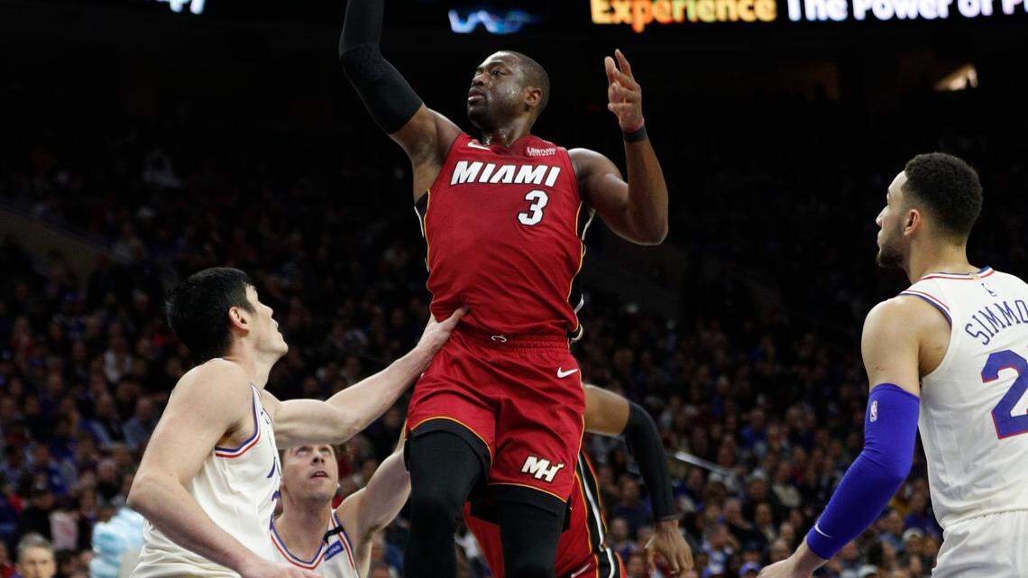Miami Heat's Dwyane Wade, right, shoots with Philadelphia 76ers' T.J. McConnell, center, and Ersan Ilyasova, left, of Turkey, defend during the first half in Game 2 of a first-round NBA basketball playoff series, Monday, April 16, 2018, in Philadelphia.