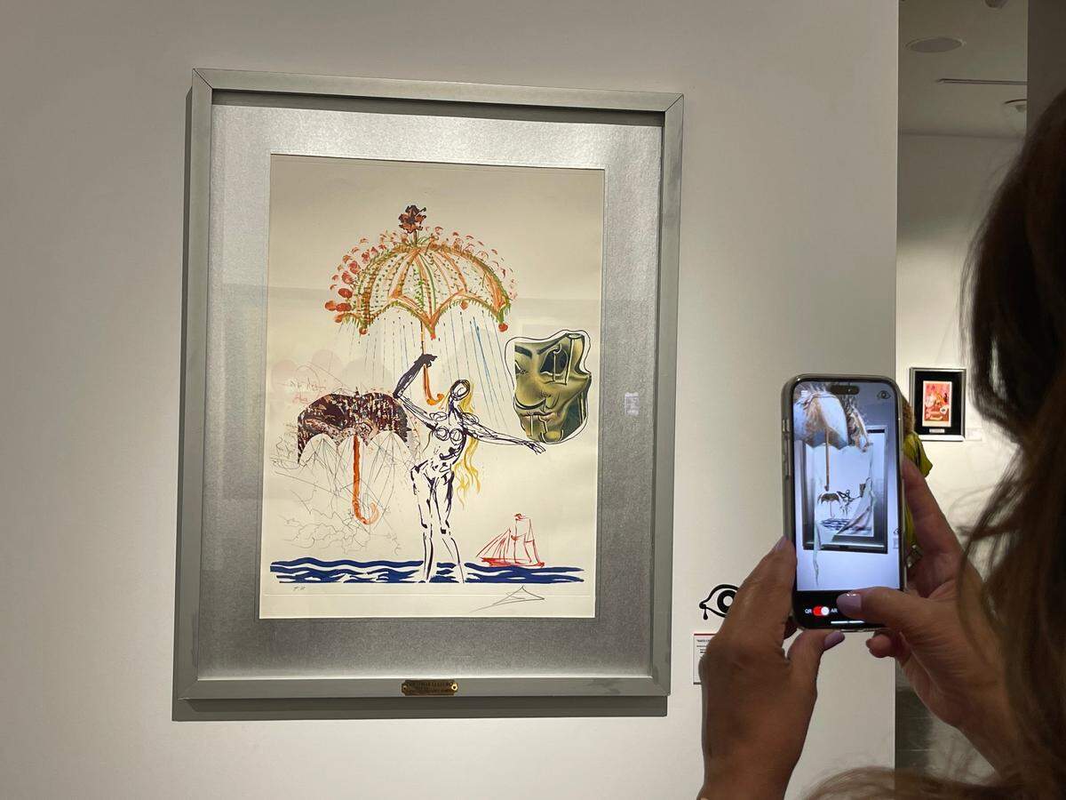 A visitor uses the Surreal 360 app to view a Salvador Dalí artwork with augmented reality.