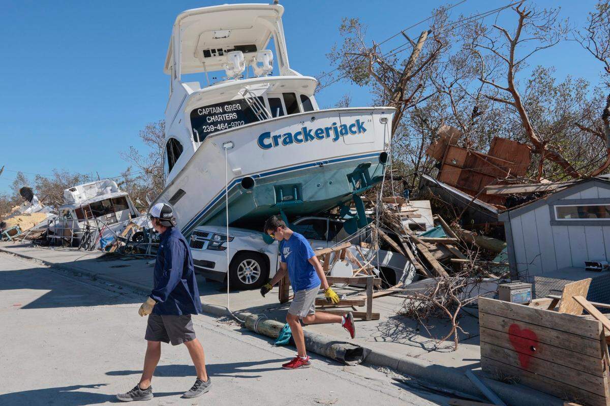 The charter boat Crackerjack sits top of a car on the side of the road on San Carlos Island on Monday, October 3, 2022. caused by Hurricane Ian.