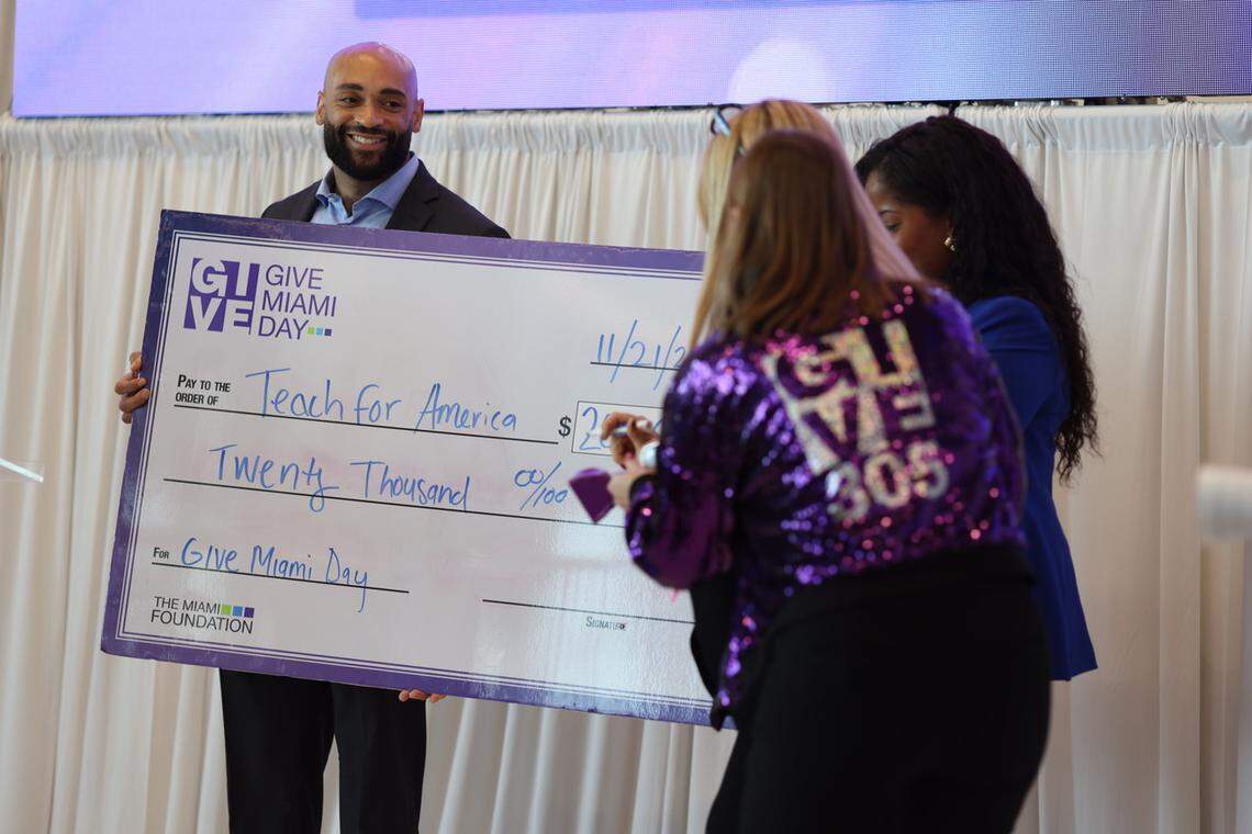 Patrick Evans, Sr., managing director for Teach for America, accepts a $20,000 donation to the organizations’ Give Miami Day fund on Thursday, Nov. 22, 2024, at Royal Caribbean. Also in the photo: Rebecca Fishman Lipsey in purple jacket, president and CEO of the Miami Foundation; Bianka Strong in blue, holding check on the right, managing director, development for Teach for America Florida Regions; Helen O’Connell, assistant vice president for Community and Destination Engagement at Royal Caribbean is in front of Fishman Lipsey.