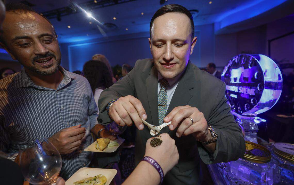 Feullah Anar watches Bourbon Steak’s Assistant General Manager Christian Rodriguez serve caviar on the back of Secil Russell’s hand as the Fontainebleau Miami Beach presents Wine Spectator's Best of the Best with 60 of the nation’s most acclaimed chefs and more than 65 of the world’s premier wineries at the resort hotel on Friday, February 20, 2026.