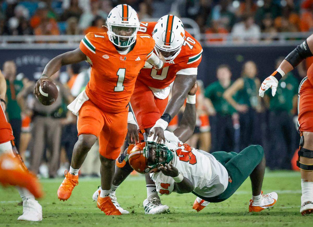 Miami Hurricanes quarterback Cam Ward (1) scrambles as Florida A&M Rattlers defensive lineman James Gardner (94) is blocked by offensive lineman Markel Bell (70) in the second half at Hard Rock Stadium in Miami Gardens, Florida, on Saturday, September 7, 2024.
