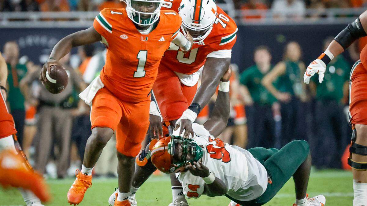 Miami Hurricanes quarterback Cam Ward (1) scrambles as Florida A&M Rattlers defensive lineman James Gardner (94) is blocked by offensive lineman Markel Bell (70) in the second half at Hard Rock Stadium in Miami Gardens, Florida, on Saturday, September 7, 2024.