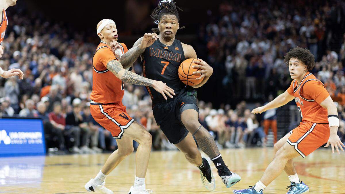 CHARLOTTESVILLE, VIRGINIA - FEBRUARY 21: Shelton Henderson #7 of the Miami Hurricanes drives between Jacari White #6 and Chance Mallory #2 of the Virginia Cavaliers in the first half during a game at John Paul Jones Arena on February 21, 2026 in Charlottesville, Virginia.  (Photo by Ryan M. Kelly/Getty Images)