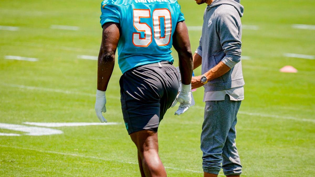 Miami Dolphins coach Mike McDaniel works with Mohamed Kamara (50) during practice at the Baptist Health Training Complex.