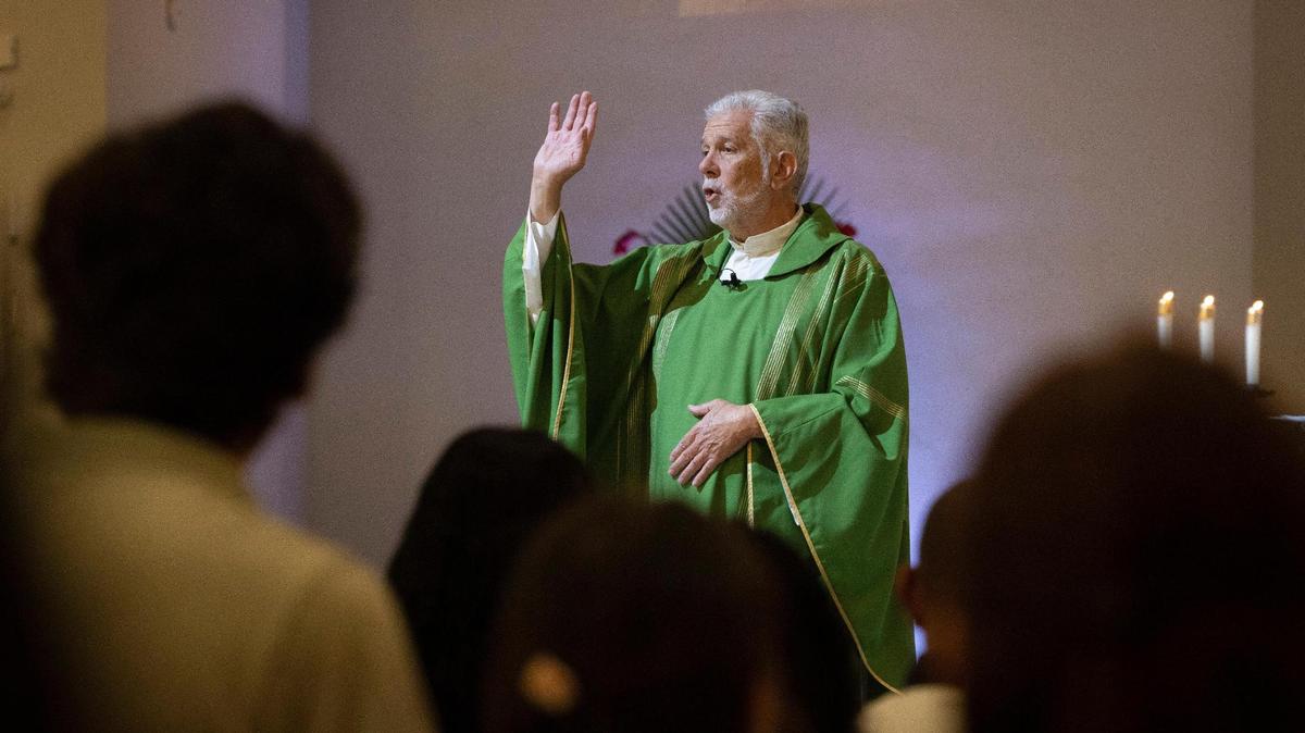 El padre José Menéndez diciendo misa antes de una ceremonia de bautismo el domingo 10 de septiembre de 2023 en la iglesia católica Corpus Christi de Miami. Muchos de los niños bautizados eran refugiados migrantes acogidos en la iglesia como parte de un esfuerzo de los Hermanos de la Calle, una organización que lucha contra la falta de vivienda.