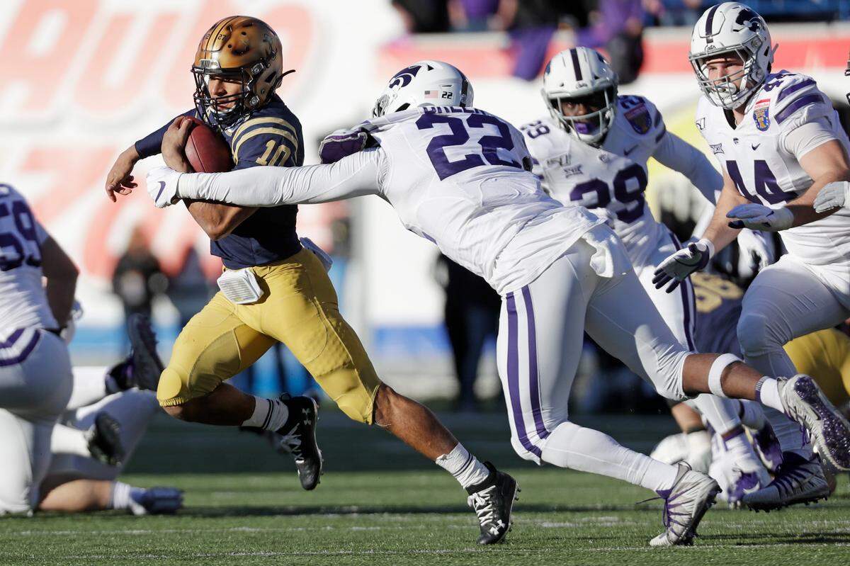 Navy quarterback Malcolm Perry (10) gets past Kansas State linebacker Daniel Green (22) in the first half of the Liberty Bowl NCAA college football game Tuesday, Dec. 31, 2019, in Memphis, Tenn. (AP Photo/Mark Humphrey)