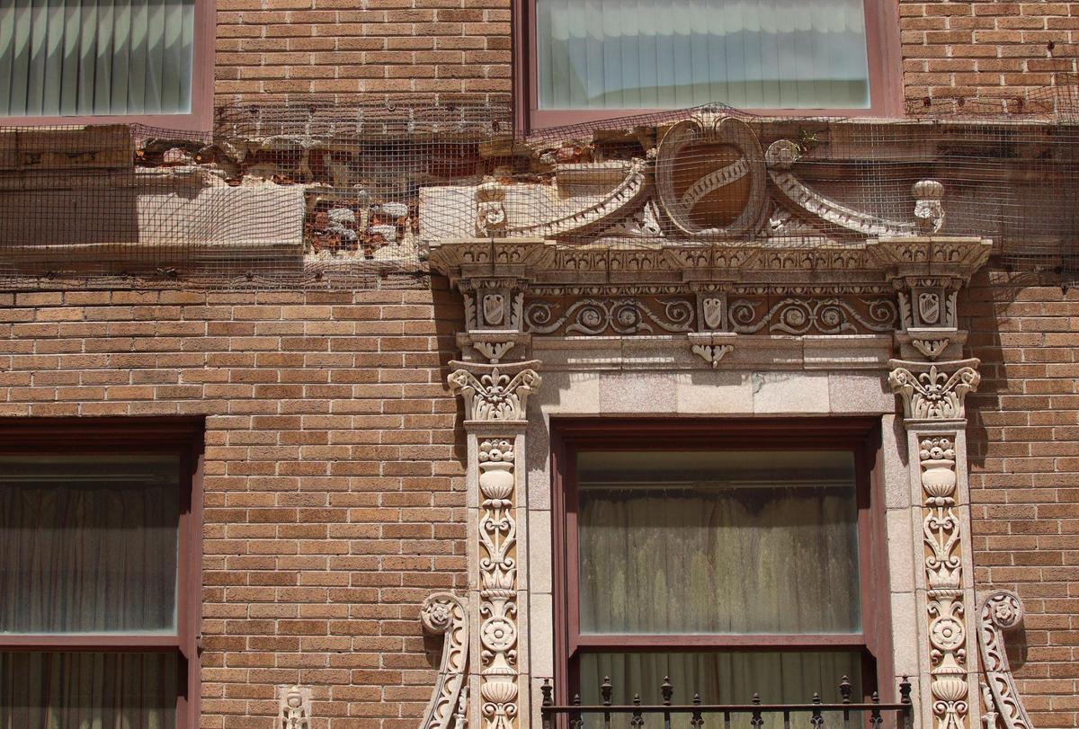 Wire mesh holds molding on the crumbling facade of the historic Olympia Theater in downtown Miami on May 19, 2021. The fragile facade is causing concern for contractors working on the Flager Street beautification project.