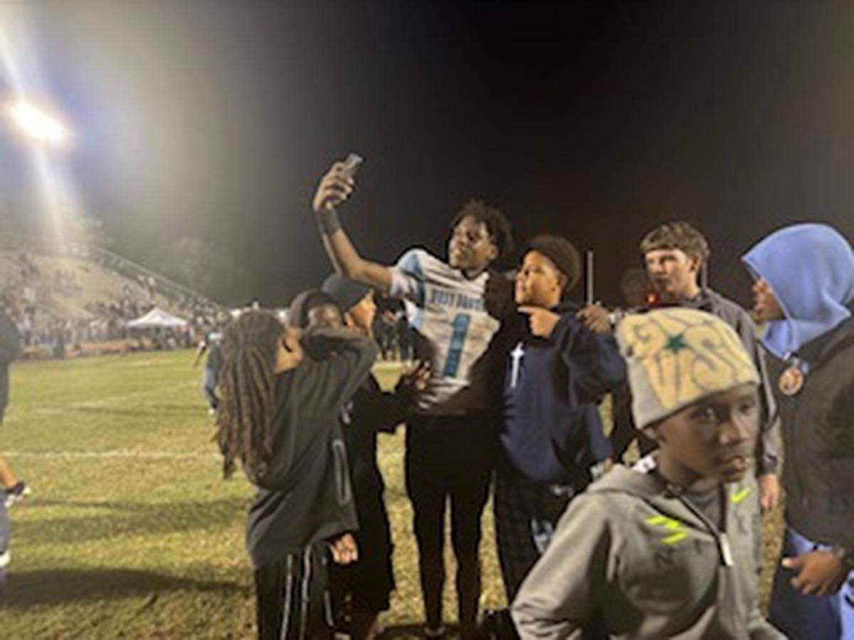 West Broward’s Amir Sears takes a selfie with fans after leading the Bobcats to a 24-17 win over Gainesville Buchholz on Friday night in a Class 6A state semifinal in Gainesville, Fla.