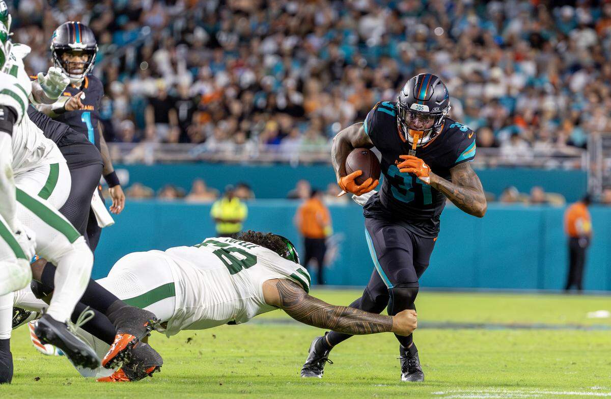 Miami Dolphins running back Ollie Gordon II (31) carries the ball as New York Jets defensive tackle Jay Tufele (78) moves in to defend during the second half of an NFL game at Hard Rock Stadium on Monday, Sept. 29, 2025, in Miami Gardens, Fla.