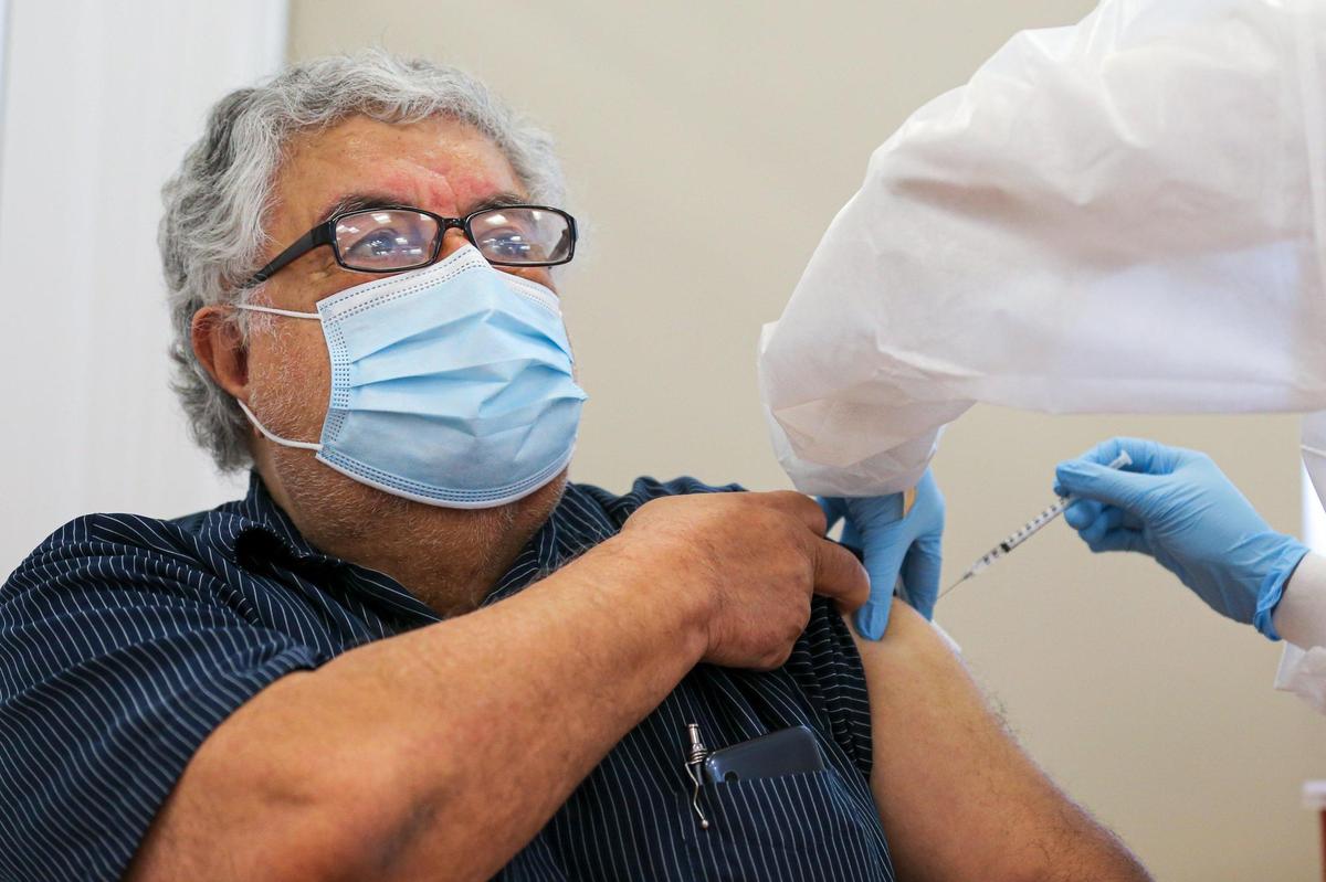 South Florida senior resident Eduardo Barton, 70, receives a dose of a COVID-19 vaccine from medical assistant Lorend Pinedo, 29, at Leon Medical Centers - Flagler on 7950 NW 2nd Street in Miami, Florida, on Thursday, January 7, 2021.