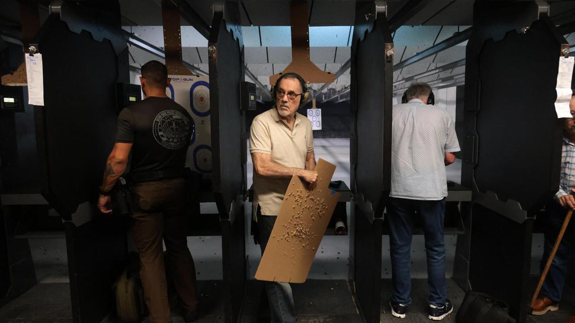 Bernardo Duelo holds a cardboard target after shooting inside the gun range at Top Gun Indoor Range at 12015 SW. 114 PL in Miami, Florida, Friday, July 18, 2025.