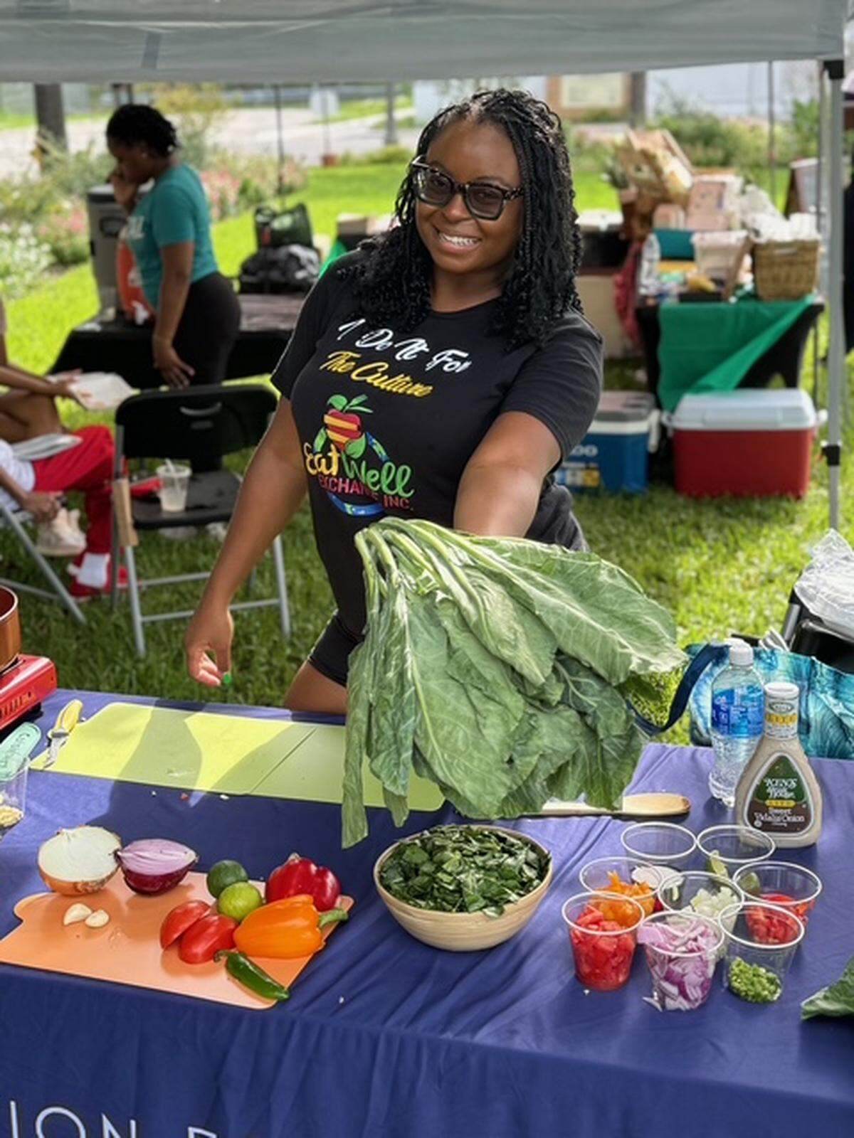 A community member shows off fresh vegetables at an Eat Well Exchange event.