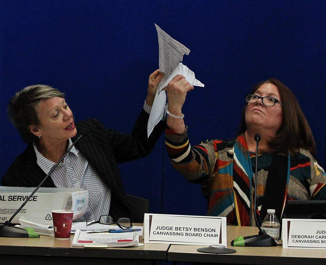Judge Betsy Benson, canvassing board chair, left, and Judge Deborah Carpenter-Toye, canvassing board member, examine a damaged ballot as the election recount continues in Broward County on Nov. 14, 2018.