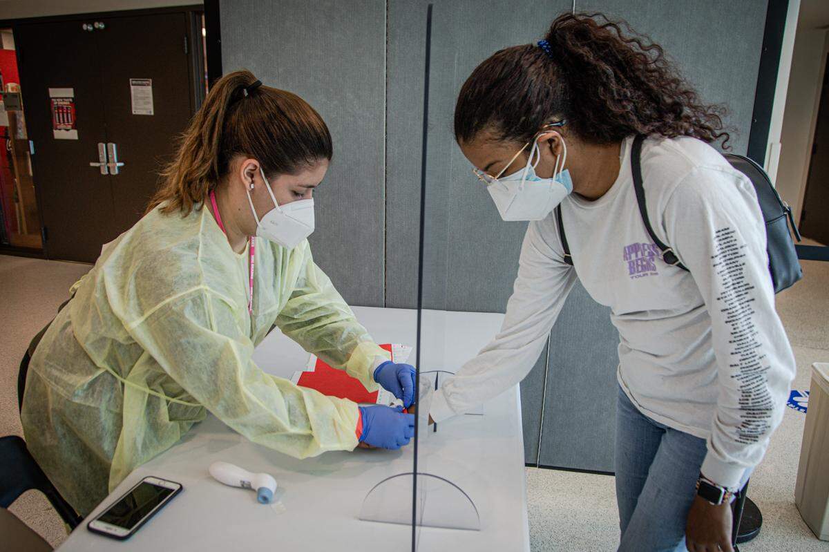 Personal de MDC verifica la temperatura de sus estudiantes y docentes en el puesto de control del Campus de Hialeah el 23 de junio de 2020.