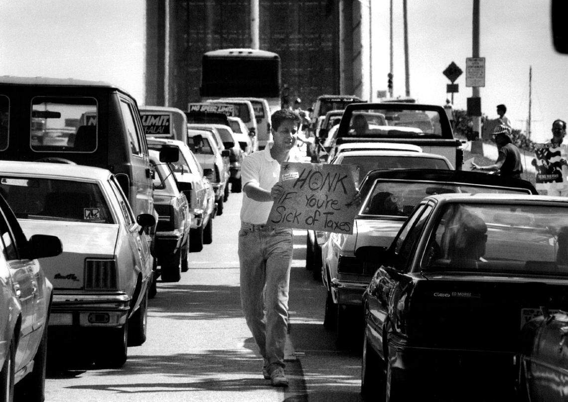 In 1991, National Taxpayer Action Day featured sign-carrying protestors urging drivers to “Honk if you’re sick of taxes,” with cars lined up on the 17th Street. Causeway in Fort Lauderdale.