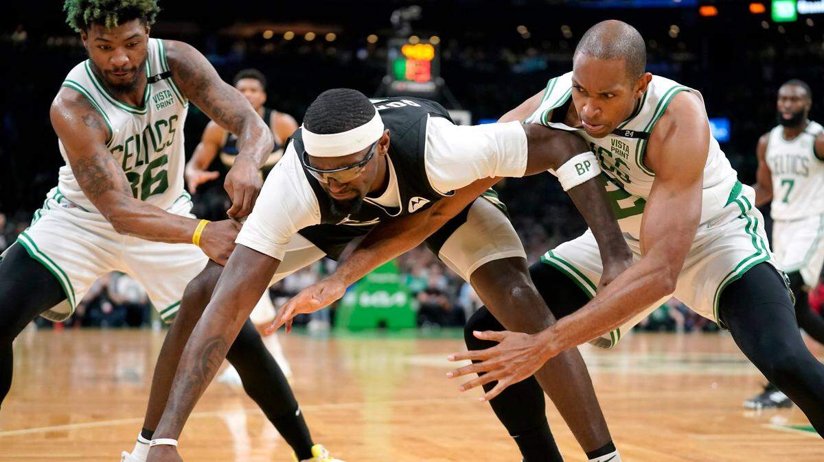 El centro de los Milwaukee Bucks, Bobby Portis, en el centro, compite por el control del balón con el escolta de los Boston Celtics, Marcus Smart, a la izquierda, y el centro Al Horford, a la derecha, durante la primera mitad del Juego 7 de una serie de playoffs de semifinales de la Conferencia Este de baloncesto de la NBA, el domingo 1 de mayo. 15, 2022, en Boston.