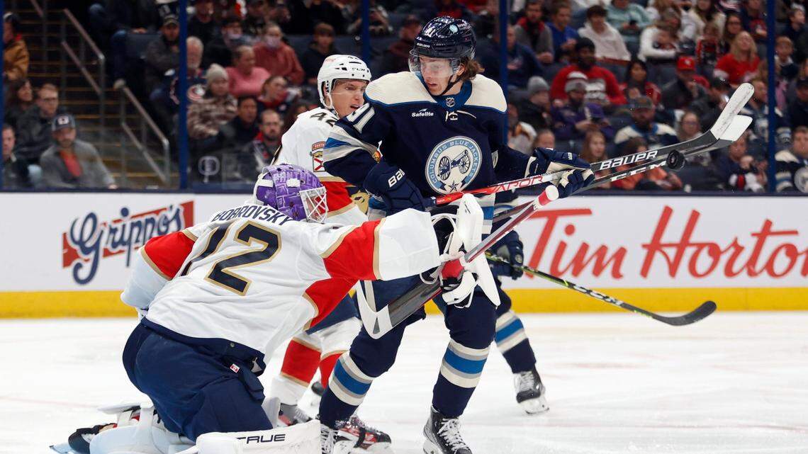 Florida Panthers goalie Sergei Bobrovsky, left, stops a shot in front of Columbus Blue Jackets forward Kent Johnson during the second period an NHL hockey game in Columbus, Ohio, Sunday, Nov. 20, 2022. (AP Photo/Paul Vernon)