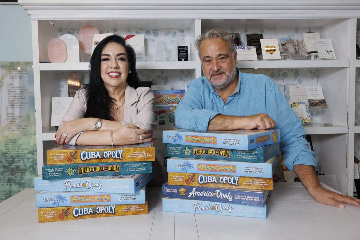 Cristina Miller, president of the Mark A. Trowbridge Chamber Foundation, and Eddy Martinez, owner of Bliss Imprint, pose with themed Monopoly games in Martinez’s shop on Monday, Sept. 22, 2025, in Coral Gables, Florida. The duo led the creation of a Gables-opoly.