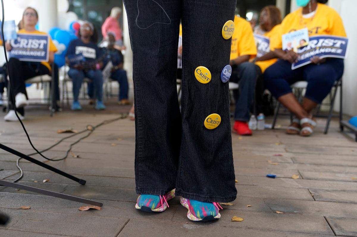 Karla Hernandez-Mats, the running mate for Democratic candidate for Florida governor Charlie Crist, wears Crist buttons on her pants as she speaks during an event at an early voting location, Sunday, Nov. 6, 2022, in Miami.