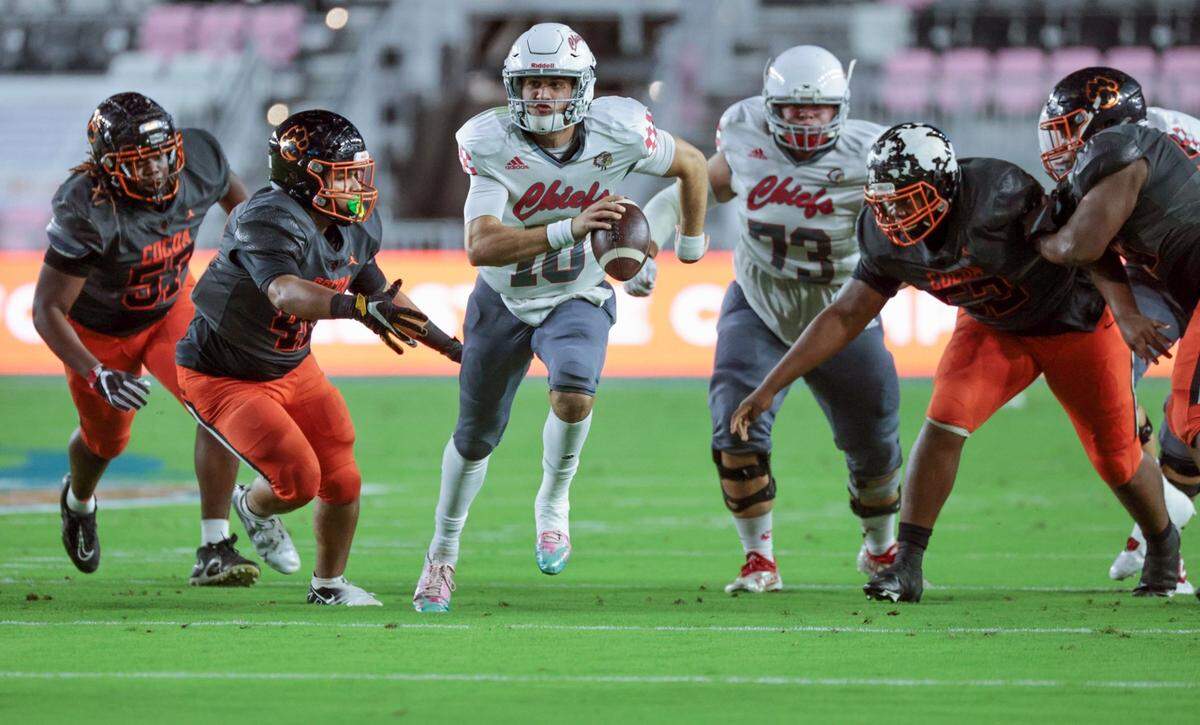 Cardinal Gibbons quarterback Dylan Rizk (10) scrambles out of the pocket during game against the Cocoa Tigers in the Class 4A championship game at DRV PNK Stadium, in Fort Lauderdale on Thursday, December 16, 2021.