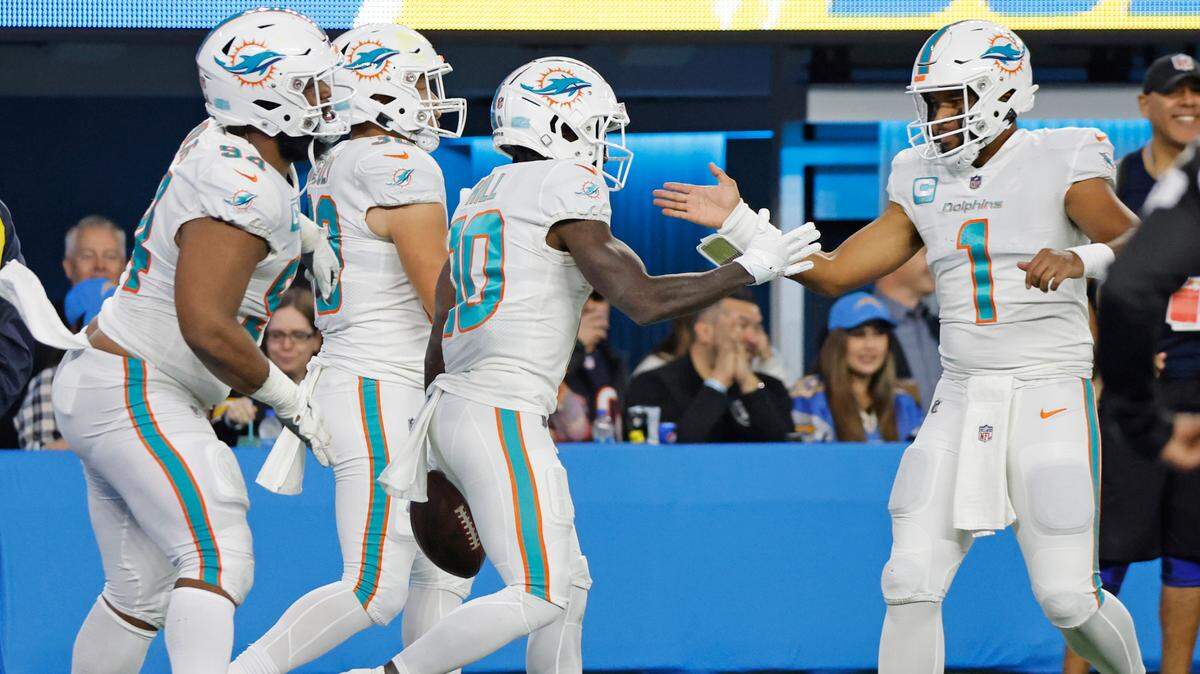 Miami Dolphins wide receiver Tyreek Hill (10) and quarterback Tua Tagovailoa (1) celebrate the score after Hill picks up a fumble by Miami Dolphins running back Jeff Wilson Jr. (23) in the second quarter during the game against the Los Angeles Chargers at SoFi Stadium in Inglewood, California on Sunday, December 11, 2022.
