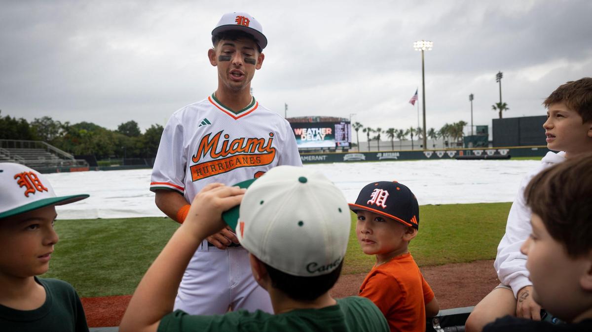 Miami Hurricanes shortstop JD Urso (2) talks with kids during a rain delay of a University of Miami baseball game against NJIT, on Sunday, Feb. 18, 2024, at Alex Rodriguez Park in Coral Gables.