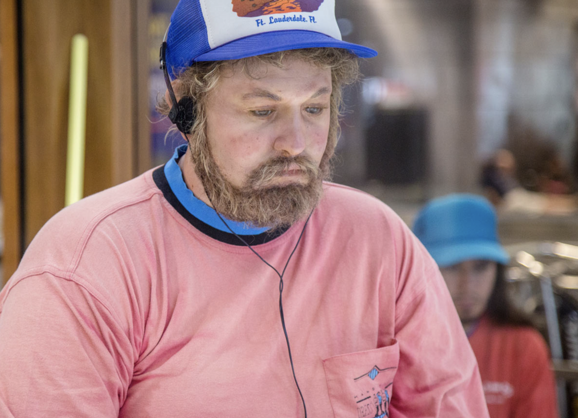 Called “Vendor with Walkman,” the installation features a man, believed to be older than 30, sitting in a folding chair, listening to a walkman, while waiting to open his toy shop at the airport.