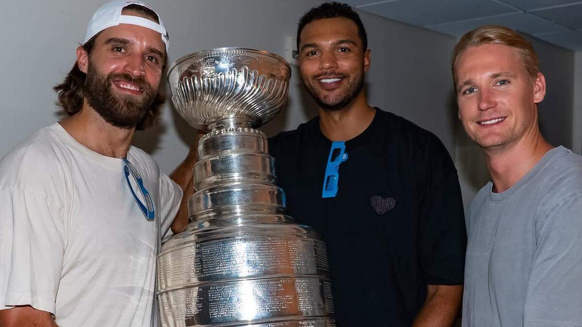 Florida Panthers defensemen Aaron Ekblad, Seth Jones and Gustav Forsling pose with the Stanley Cup during a Coldplay concert at Hard Rock Stadium on Sunday, July 27, 2025.