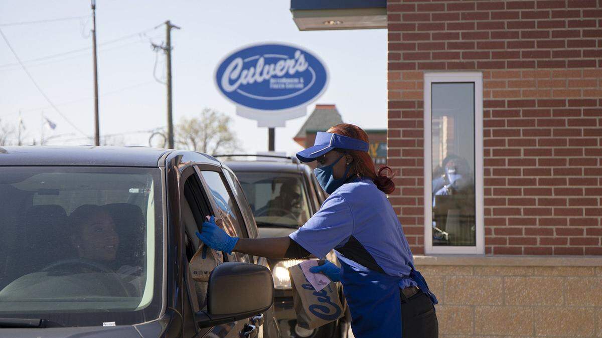 Culver’s employee Teesha Nelson hands a drive-thru customer their order on Nov. 8, 2021, outside the restaurant chain’s newest location in Pullman on its opening day.