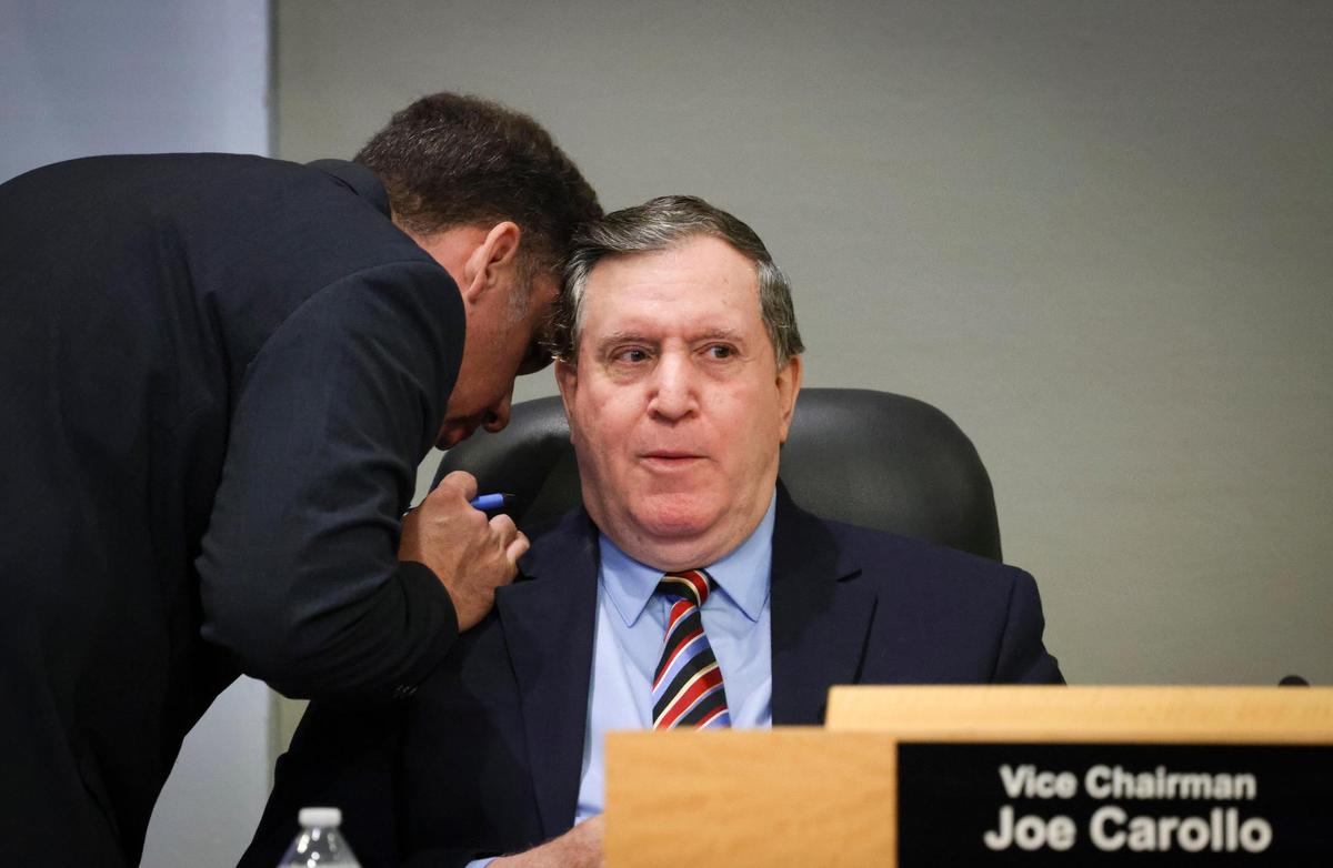 Will Ortiz leans in to speak to then-Commissioner Joe Carollo during a Miami City Commission meeting on Thursday, Nov. 21, 2024, at Miami City Hall in Coconut Grove.