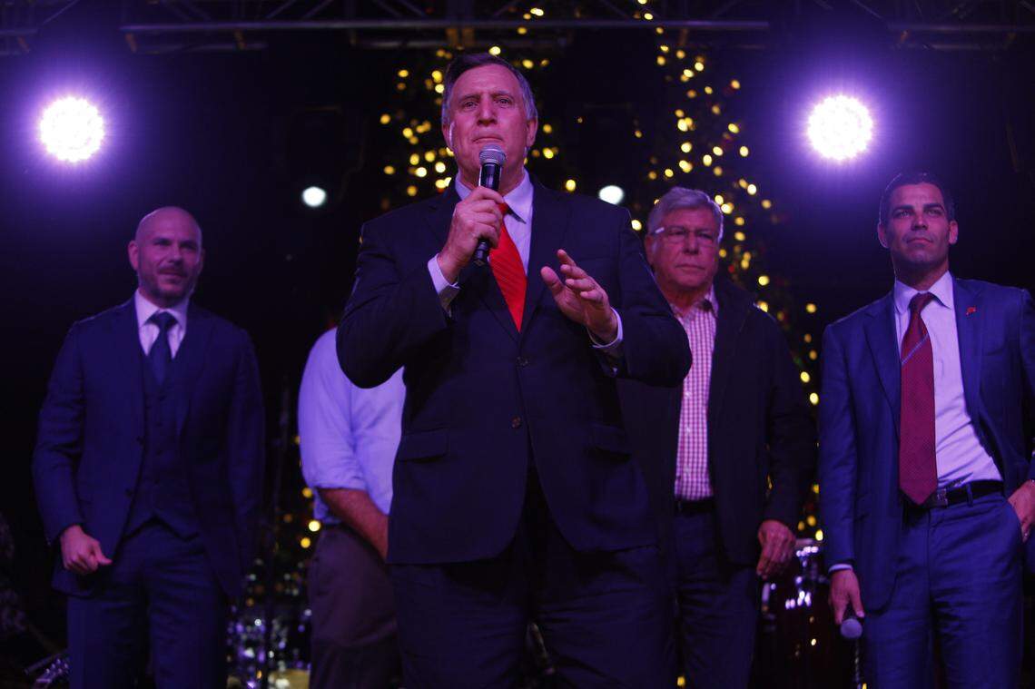 Commissioner Joe Carollo speaks at an event while Miami Rapper Pitbull, left, Commissioner Manolo Reyes, second from right, and current Mayor of the City of Miami Francis X. Suarez, right, stand behind him during an event he hosted on Calle Ocho on Nov. 30, 2018.