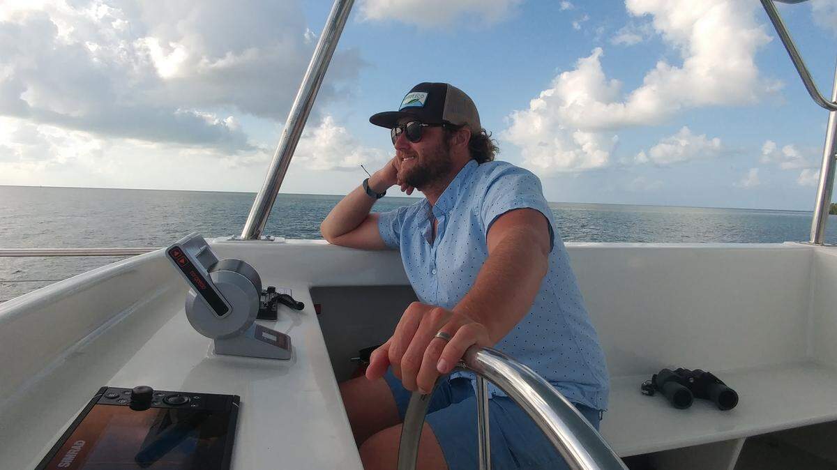 Key West boat captain Billy Litmer sits at the helm of his solar-powered electric charter boat on a recent day in February 2019.