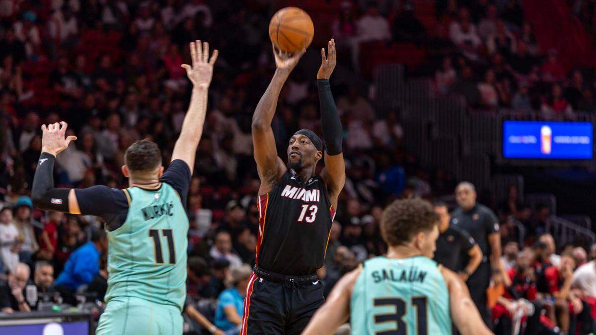 Miami Heat center Bam Adebayo (13) shoots a jumper over Charlotte Hornets center Jusuf Nurkic (11) during the first half of an NBA game at Kaseya Center on March 23, 2025, in Miami.